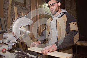Close-up of a carpenter doing woodwork. a small business owner was cutting a wooden Board with a circular saw in a workshop