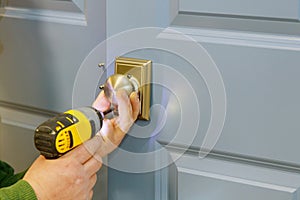Close-up carpenter hands with doorlock during lock process installation