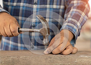 Close-up the carpenter hit nail to wood chip in workshop