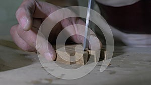 Close-up, a carpenter makes a dovetail on a wooden part with a chisel, on a workbench. woodworker processes a wooden board. 4k. 4k