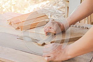 Close up, carpenter man cutting a plank of wood in the working using a circular saw in workshop