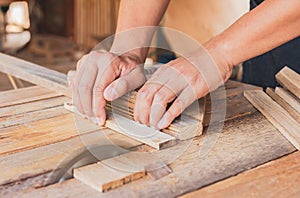 Close up, carpenter man cutting a plank of wood in the working using a circular saw in workshop