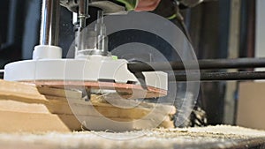 Close-up of a carpenter`s hand working with an manual electric cutter in a home workshop. Finishing wooden parts in slow