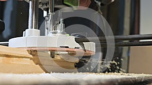 Close-up of a carpenter`s hand working with an manual electric cutter in a home workshop. Finishing wooden parts in slow