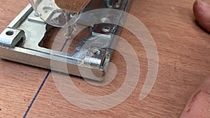 Close Up. Carpenter sawing wood board with an electric jigsaw. Close up of a man sawing wood with fretsaw 1