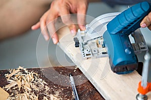 Close-up of a carpenter using a circular saw.