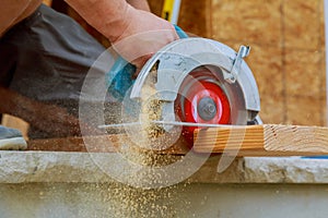 Close-up of a carpenter using a circular saw to cut a large board of wood