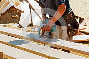 Close-up of carpenter using a circular saw to cut a large board of wood