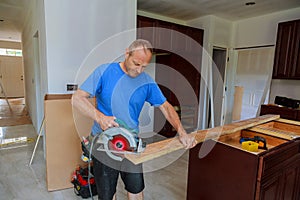 Close-up of carpenter using a circular saw to cut a large board of wood