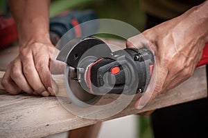 Close up of a carpenter using a circular saw to cut a wood, Carelessness at work concept