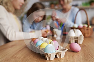 Close up of carton of colored Easter eggs in the table