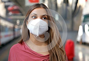 Close up of casual woman waiting train with KN95 FFP2 protective mask at train station