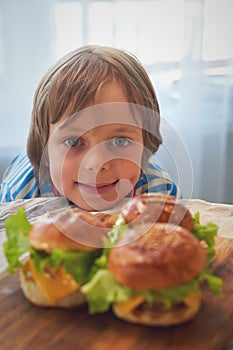Close up of caucasian boy eating hamburger at barbecue
