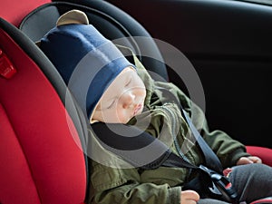 Close Up caucasian cute baby boy sleeping in modern car seat. Child traveling safety on the road. Safe way to travel