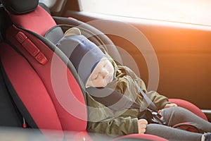 Close Up caucasian cute baby boy sleeping in modern car seat. Child traveling safety on the road. Safe way to travel