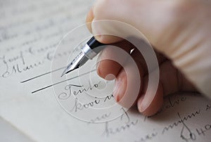 Close-up of a Caucasian female hand holding a fountain pen and signing a purchase contract