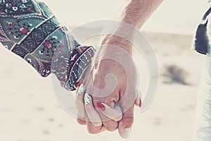 Close up of caucasian hands holding with love and relationship outdoor - young and adult man and woman couple concept - together
