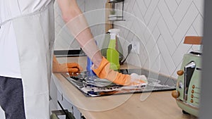 Close-up of a caucasian man cleaning a kitchen panel in the kitchen