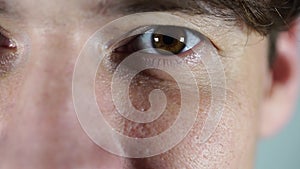 Close up of a caucasian man's bloodshot eye. Red male blue eye close up macro