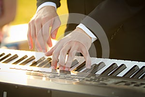 Close up of Caucasian man`s hands playing a keyboard.