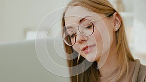 Close up Caucasian woman female face girl in glasses eyes look at laptop screen. Freelancer smiling businesswoman busy