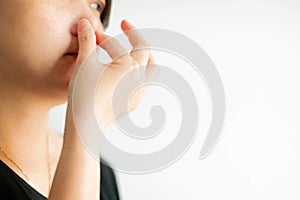 Close-up of caucasian woman use thumb and forefinger pinch her nose when scent bad smell