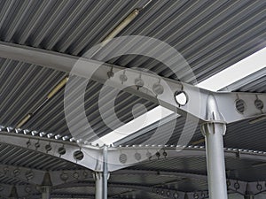 A close-up of a ceiling of a huge covered parking place. Inside bright view of iron construction as a background.