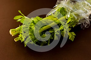 closeup celeri leaves on brown background photo