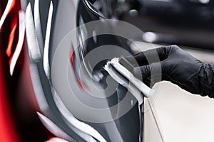 Ceramic coating application on car paint using applicator pad during professional car detailing