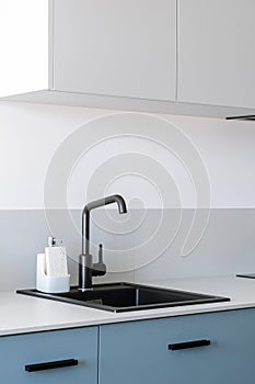 Close up of ceramic sink with tap on grey counter top in kitchen