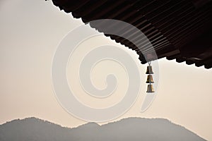 The close-up of a chain of bells under the eaves of the Chinese buddhist temple.