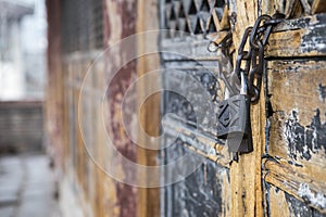 Close up of a chain is hooking on old classic chinese style door with a lock