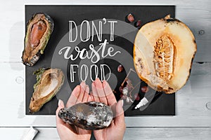 Close up of a chalkboard with Don`t waste food lettering and rotten fruits