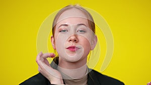 Close-up of charming Caucasian redhead woman looking at camera sending air kiss. Portrait of beautiful smiling