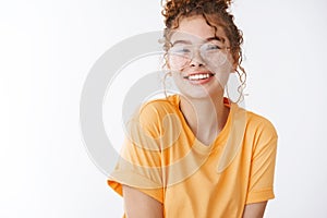 Close-up charming teenage redhead girl wearing glasses messy curly bun smiling laughing friendly expressing happiness