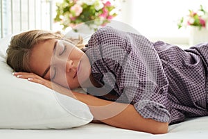 Close-up of charming young woman dreaming in her bed in sunlit b