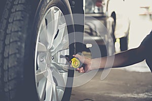 Close-up checking car tyre pressure with gauge