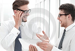 Close up.cheerful employees looking at the digital tablet screen