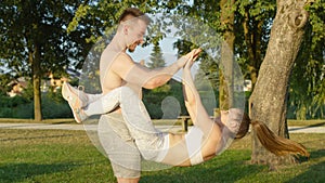 CLOSE UP: Cheerful girl does sit ups with her legs wrapped around her boyfriend.