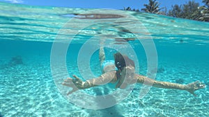 CLOSE UP: Cheerful woman In bikini enjoys diving in the beautiful turquoise sea.