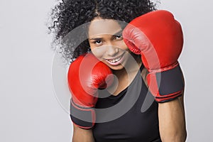 Close up of cheerful woman in fight stand with red boxing gloves