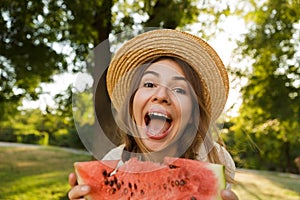 Close up of cheerful young girl in summer hat spending time at the park
