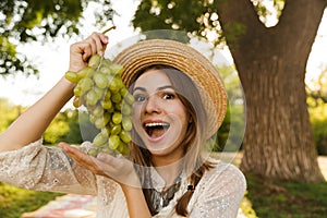 Close up of cheerful young girl in summer hat spending time at the park,