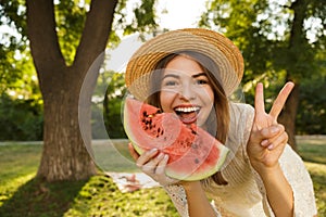 Close up of cheerful young girl in summer hat spending time at the park