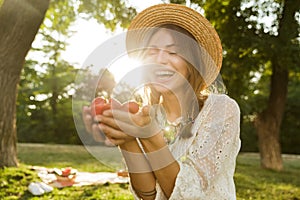 Close up of cheerful young girl in summer hat spending time at the park