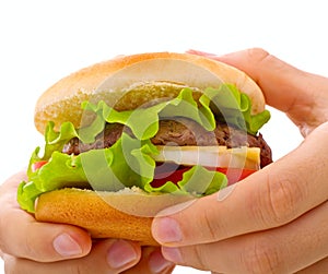 A close up cheeseburger being held in hands