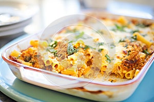 close-up of a cheesy baked ziti casserole with a gold crust