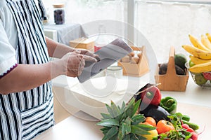 Close-up of chef`s hand using tablet to buy fruit and vegetables online.