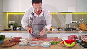 A close-up of the chef`s hands cutting carpaccio