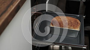 Close-up of a chef\'s hands taking baked bread out of the oven. the cook bakes bread